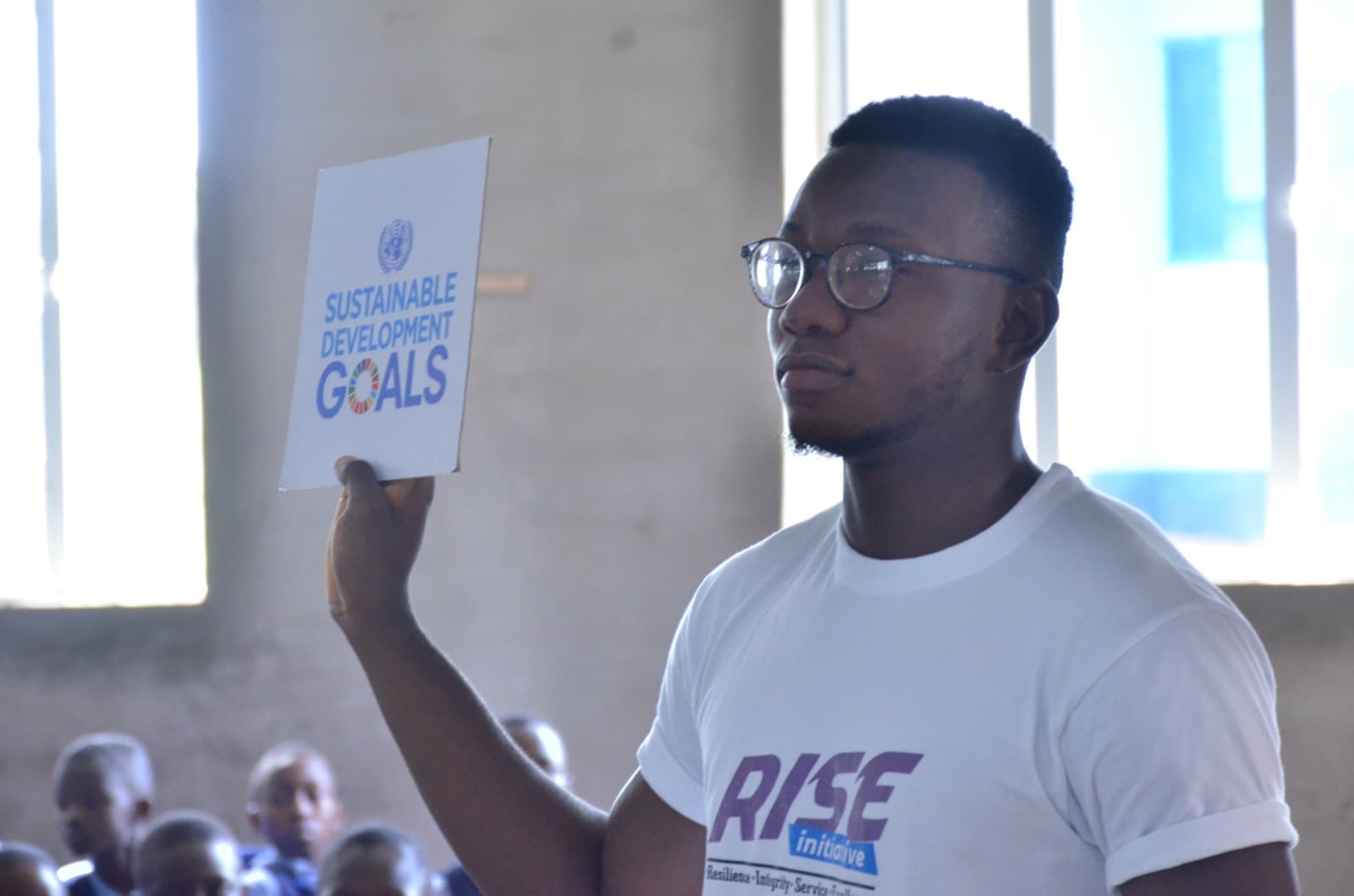 A student holding up a Sustainable Development Goals card at Best Legacy International Secondary School, 2019.